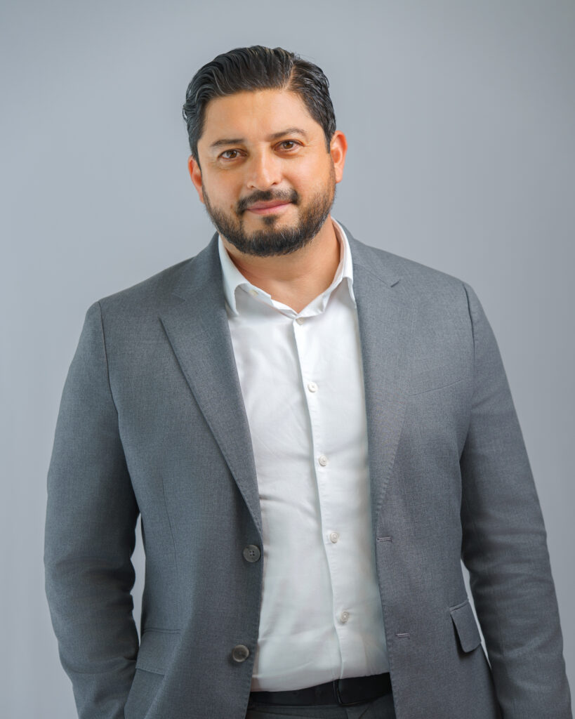 A man in a gray suit jacket and white shirt.
